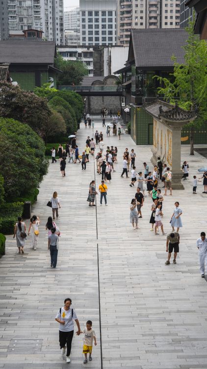 成都街区实拍,人们走在传统屋顶与现代楼宇之间